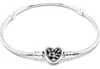 A silver bracelet with a heart-shaped charm featuring a tree of life design, presented on a white background. Voir les images du produit