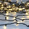 A close-up view of a string of warm white LED Christmas lights coiled on a white surface. Podgląd zdjęcia produktu