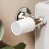 A close-up shot of a smart radiator thermostat attached to a radiator, with a plant in the foreground. Produktbild-Vorschau