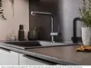 A modern kitchen sink area with a faucet, sink, and countertop accessories. Anteprima dell’immagine prodotto