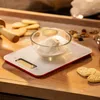 A digital kitchen scale with a bowl of flour and cookies in the background. Produktbild-Vorschau