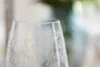 A close-up of a clear wine glass with an etched floral pattern. Anteprima dell’immagine prodotto