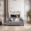 Two dogs are sitting on a gray pet sofa in a well-decorated living room with a fireplace. Voir les images du produit