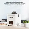 A white product with a black top sits on a table in front of a couch and a potted plant. Produktbild-Vorschau