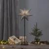 A star-shaped lamp is displayed on a wooden surface with gifts and a small Christmas tree, suggesting a festive or decorative setting. Podgląd zdjęcia produktu