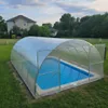A covered swimming pool in a grassy yard with a house in the background. Produktbild-Vorschau