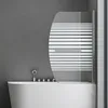 A modern bathroom with a white bathtub and a glass shower screen with horizontal stripes. Produktbild-Vorschau