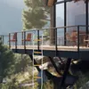 A rope ladder is attached to a balcony of a modern house built on a cliffside, overlooking a misty forest and mountains. Náhled obrázku produktu
