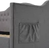 A close-up view of the side of a grey upholstered bed frame, showing a small fabric pocket attached to the side. Anteprima dell’immagine prodotto