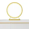A circular LED mirror with a gold frame sits on a white dresser. Produktbild-Vorschau