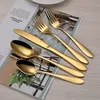 A set of gold cutlery laid out on a magazine. Anteprima dell’immagine prodotto