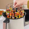 A hand is placing a rack of colorful skewers into an air fryer. Náhľad obrázku produktu
