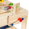 A close-up view of a wooden toy workbench with various accessories like screws, nuts, and a vise. Náhled obrázku produktu