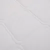 A close-up view of a white quilted mattress surface. Produktbild-Vorschau