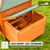 Close-up view of a wooden chicken coop with the nesting box open, showing internal dividers. The coop is situated on green grass. Produktbild-Vorschau