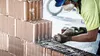 A construction worker is cutting bricks with a saw. Voir les images du produit