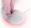 Feet in pink striped pajamas are inserted into a fluffy gray electric foot warmer, with a red glow emanating from the bottom. Produktbild-Vorschau