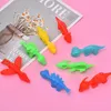 Auswahl an kleinen, bunten Plastik-Dinosaurierspielzeugen in Rot, Grün, Blau und Gelb auf rosa Hintergrund Produktbild-Vorschau