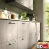 A modern kitchen with gray stone-effect cabinets and a window letting in natural light. A coffee machine is on the counter. Produktbild-Vorschau