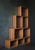 A pyramid-like arrangement of wooden crates stacked against a dark, textured wall. Produktbild-Vorschau