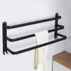 A black aluminum towel rack mounted on a white wall, with one towel draped over the middle bar. Voir les images du produit