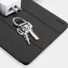 A close-up shot of a black tablet case with keys and a white power adapter on it. Náhľad obrázku produktu