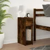 A bedside table with a drawer and an open shelf, placed next to a bed. A lamp and an alarm clock are on top of the table, and books are in the shelf. A potted plant is to the left. Podgląd zdjęcia produktu