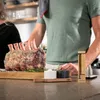 A person is preparing a large roast beef with a thermometer. Náhled obrázku produktu