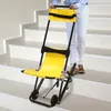 A person is using a yellow and black stair chair on a set of stairs. Podgląd zdjęcia produktu