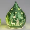 A green glass teardrop-shaped decorative light with a frosted winter scene of trees and deer. Produktbild-Vorschau