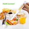 A hand holds a salt content tester over a breakfast plate with eggs, sausages, and toast. The background shows more breakfast items like croissants, oranges, and juice. Náhled obrázku produktu