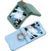 Two flip phone cases with ring stands, one green and one blue, are displayed against a white background. Produktbild-Vorschau
