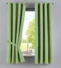 A pair of light green curtains are tied back with a fabric tie, revealing a window with a view of trees and a grassy field. A pink vase and a white ceramic pot sit on the windowsill.