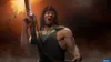 A muscular man with long hair, wearing a black tank top, is firing a rifle. Shell casings are flying out of the gun. The background is dark and smoky with an orange glow. Produktbild-Vorschau