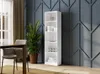 A white bookshelf filled with dishes and glasses, placed in a room with a decorative blue wall and a dining table with chairs. Produktbild-Vorschau