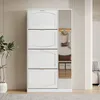 A white shoe cabinet with a mirror on the right side, placed in a hallway or entryway. It features four flip-down compartments and a shelf in the mirrored section, along with hooks for hanging items. A potted plant is visible on the left. Náhľad obrázku produktu