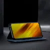 A smartphone in a blue flip case, displayed in a studio setting with a dark background. Produktbild-Vorschau