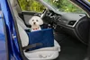A small white dog sits in a blue velvet dog car seat placed on the passenger seat of a car. Produktbild-Vorschau
