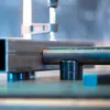 Close-up of metal components, possibly part of a welding table or jig, resting on a surface. Náhľad obrázku produktu