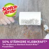 A hand holding a lint roller covered in glitter over a wooden surface. Produktbild-Vorschau