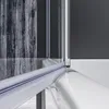 Close-up view of a shower enclosure corner, showing the glass and sealing strip against a white bathtub. Podgląd zdjęcia produktu