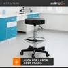 A black rolling stool with a silver base and footrest is shown in a laboratory or practice setting, with cabinets and a microscope in the background. Produktbild-Vorschau