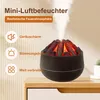 A volcano-shaped aroma diffuser emitting mist, placed on a wooden surface next to a potted plant. Produktbild-Vorschau