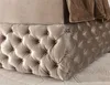 A close-up view of the tufted base of a bed, with a brown blanket draped over the top. Produktbild-Vorschau
