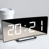 A digital alarm clock with a mirrored display showing the time 20:21, placed on a surface next to a white disposable coffee cup. Produktbild-Vorschau