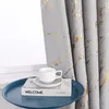 A close-up of a gray curtain with gold marbling pattern, a white coffee cup and saucer, and a book on a blue tray. Produktbild-Vorschau