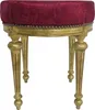 A round stool with a patterned bordeaux red fabric seat and gold-colored legs.