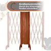 A wooden dog gate is shown in a folded position, with a faded background of an expanded gate and silhouettes of dogs. Produktbild-Vorschau