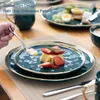 A table setting with dessert plates, a mug, and cutlery, suggesting a meal or dessert. Náhled obrázku produktu