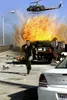 A man runs from an exploding car on a bridge, with a helicopter overhead. Náhľad obrázku produktu